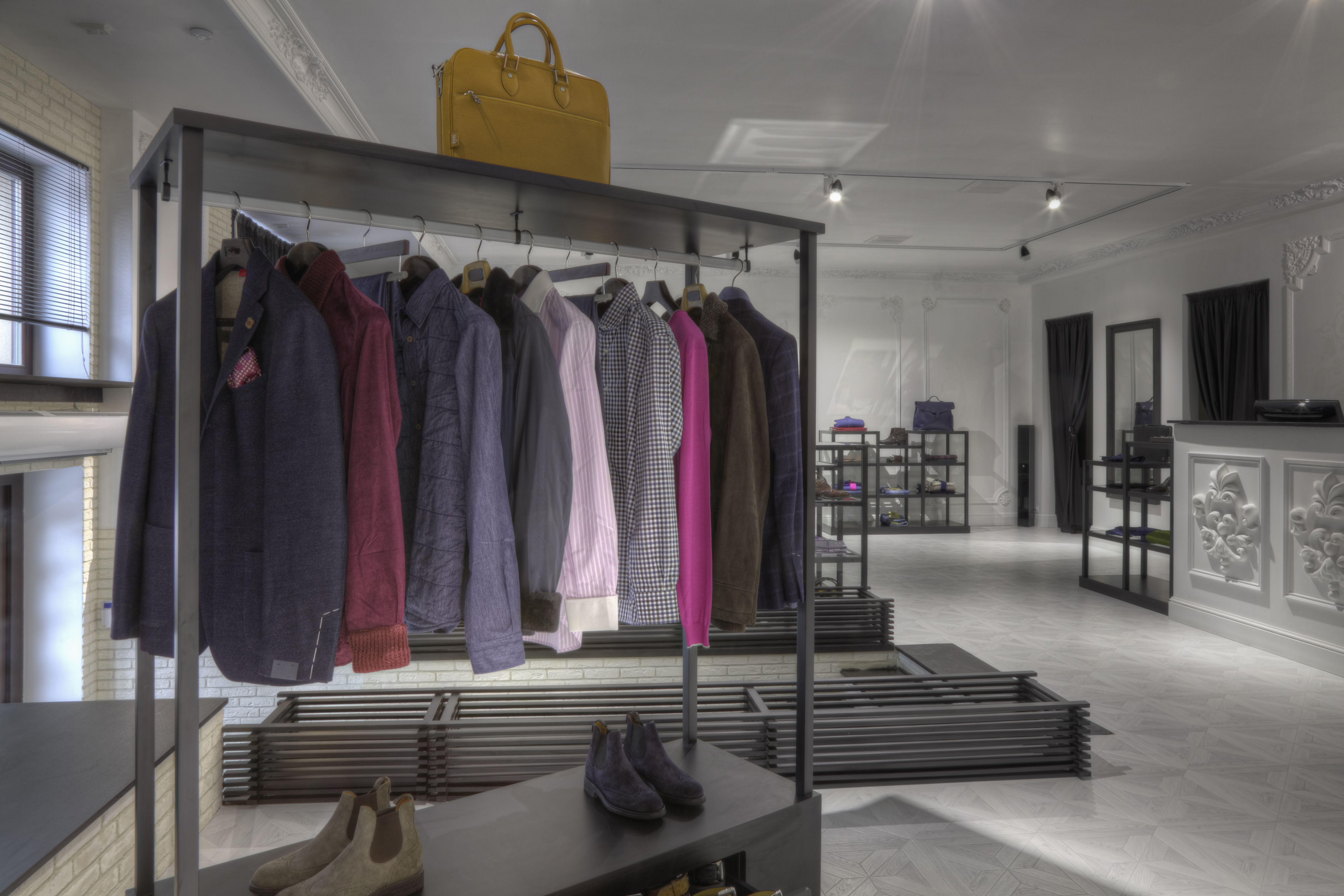 Suits and shoes on rack in clothing store for men