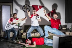 Four young adult men friends watching football on television: Goal