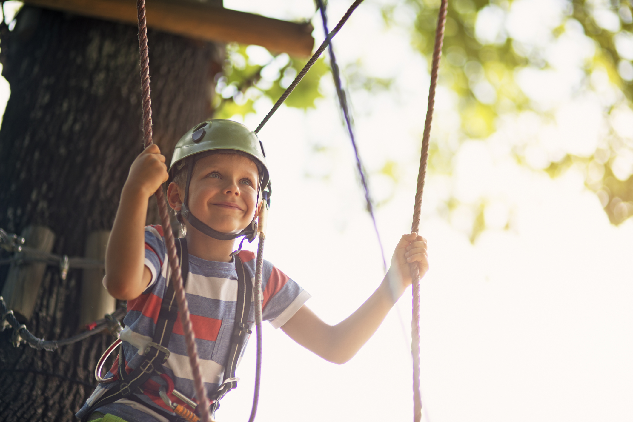 Little boy walking in outdoors ropes course