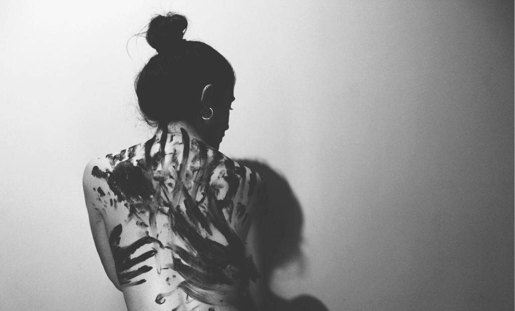Rear View Of Woman Standing Against Wall