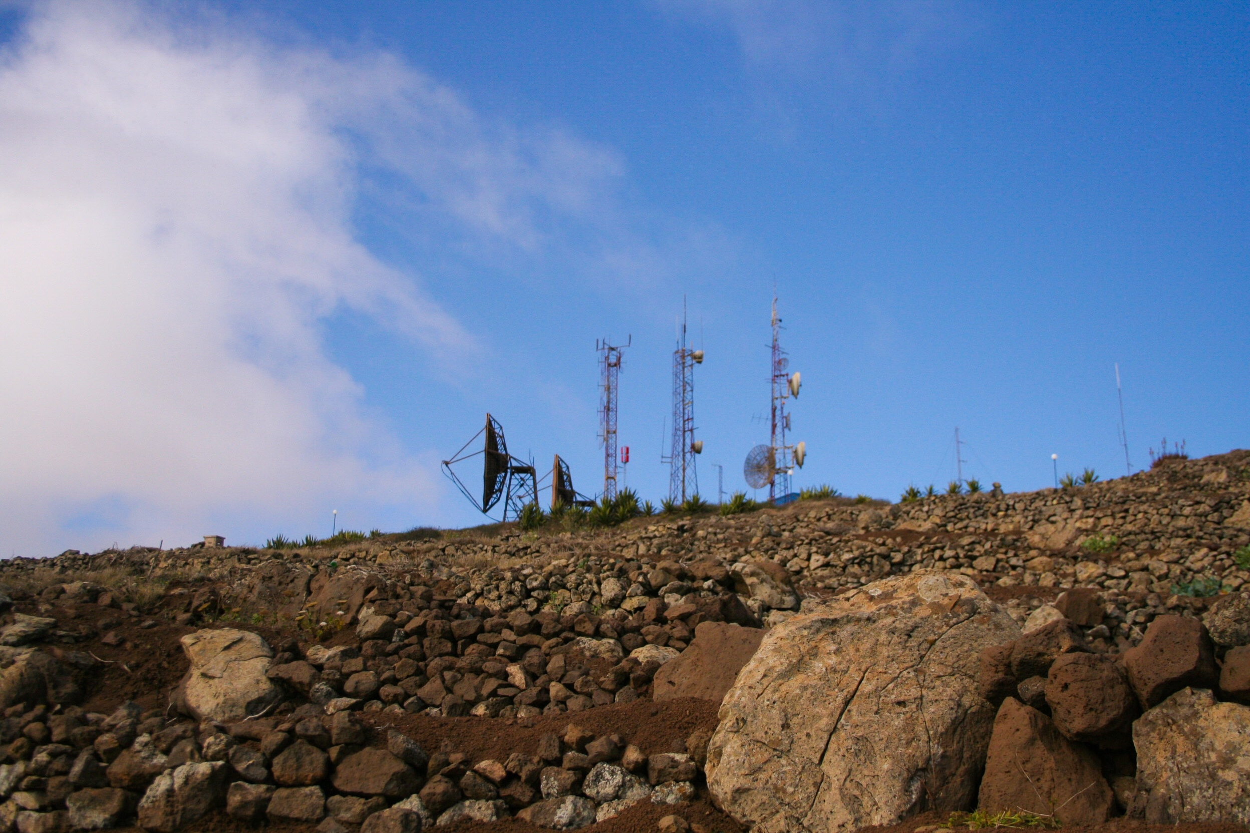 Low Angle View Of Repeater Towers And Satellite Dish On Field