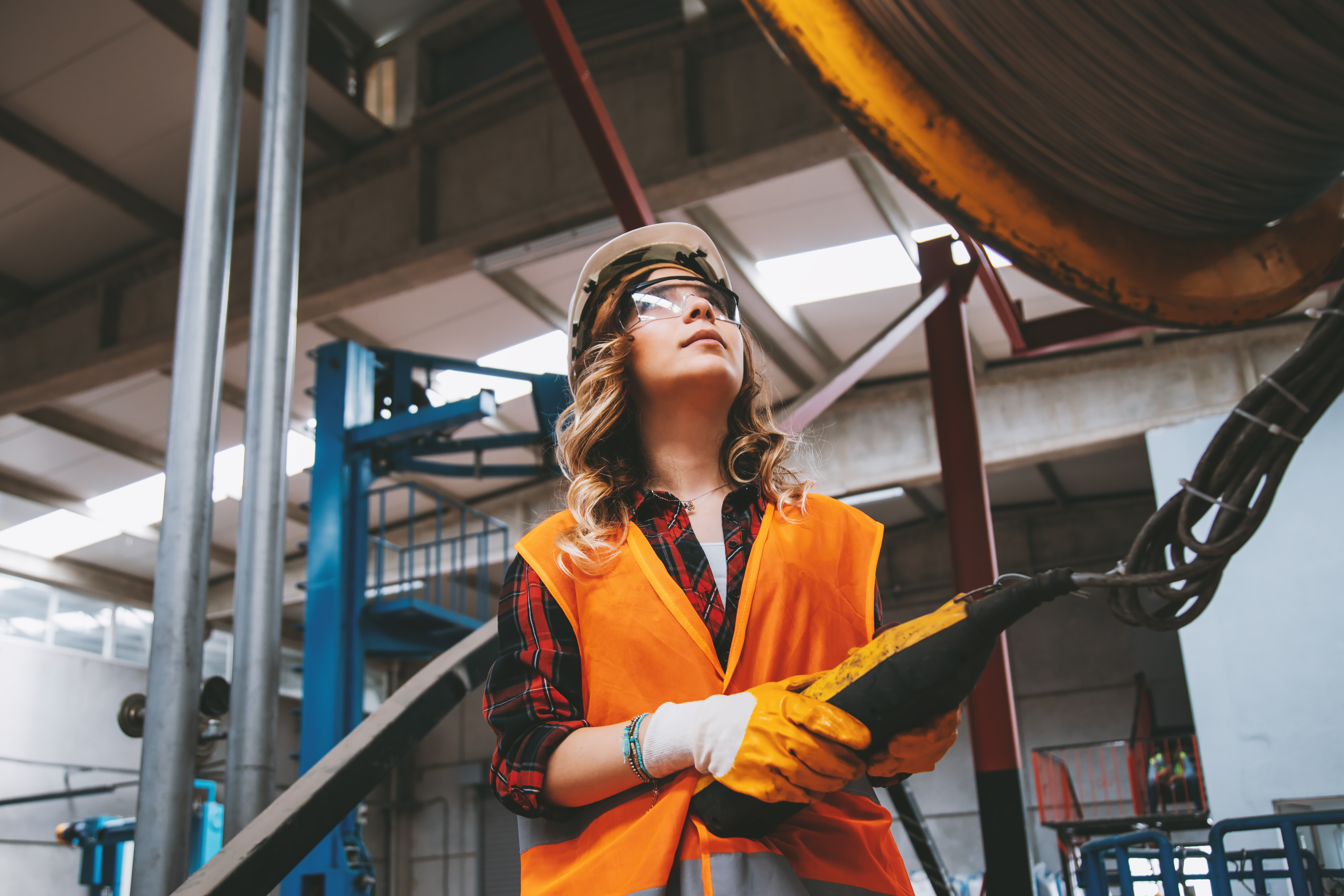 Young engineer woman holding and working with remote control for operating crane