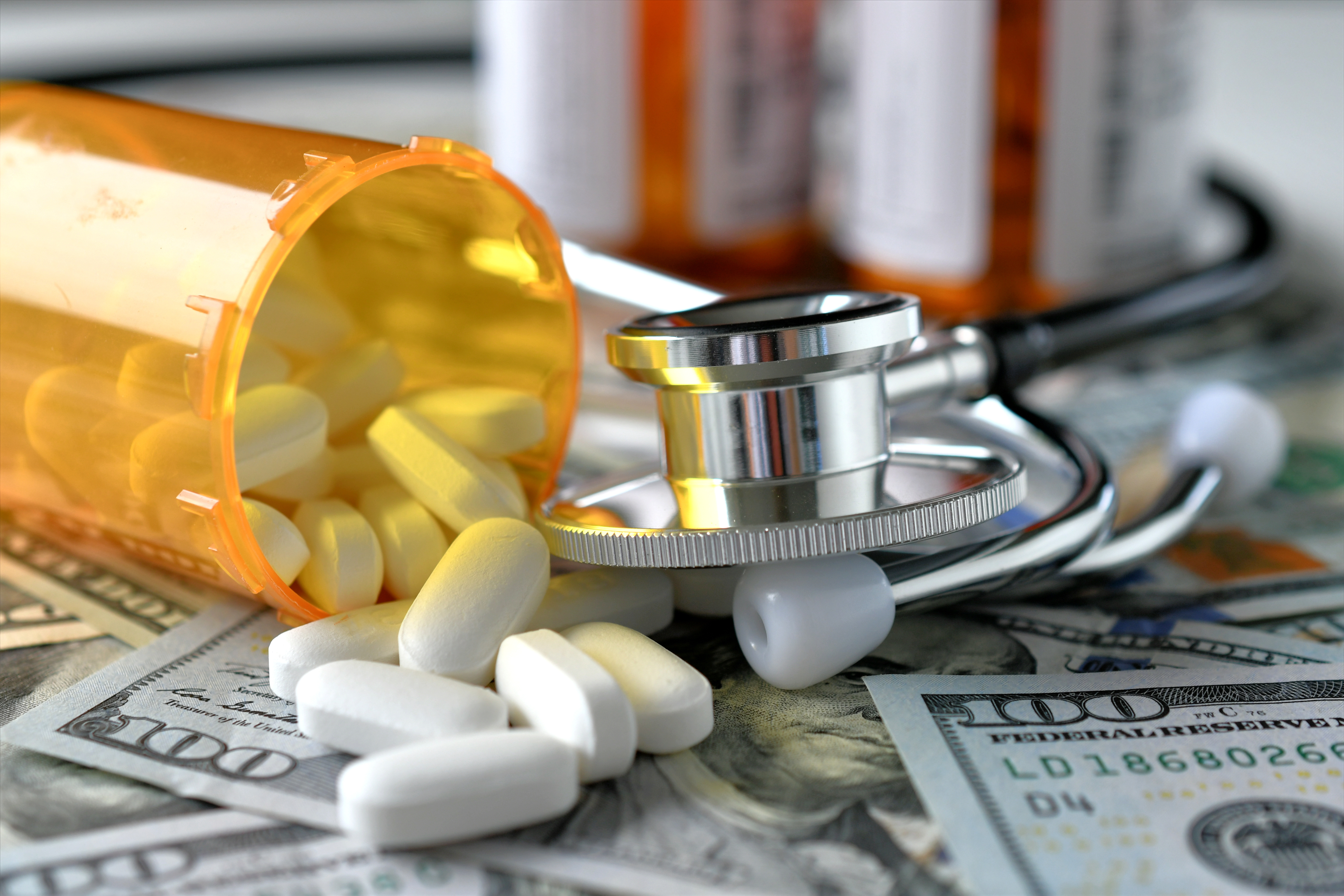 High Angle View Of Medicines With Stethoscope And Paper Currencies On Table
