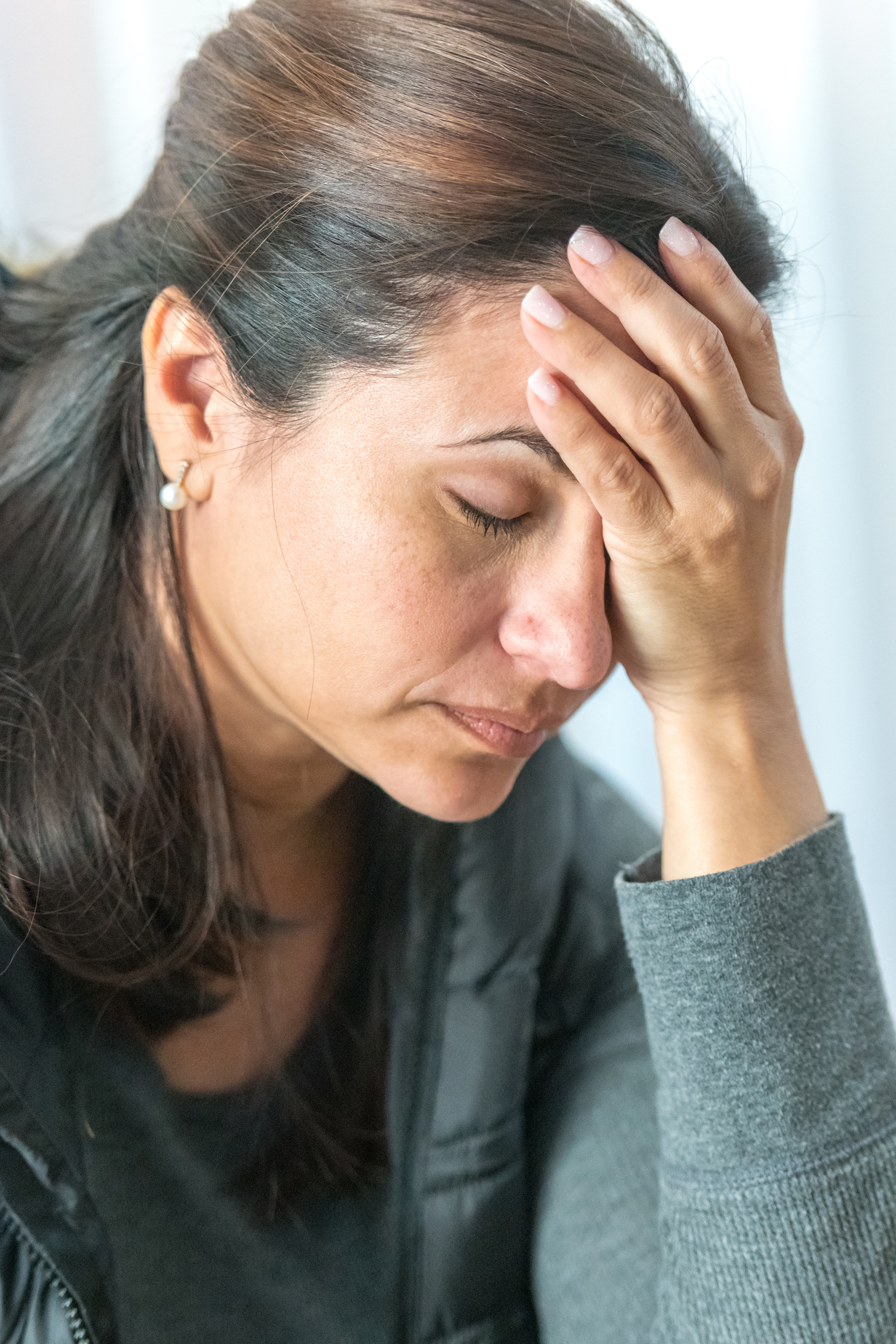 Mature woman posing with her eyes closed with her hand in her head