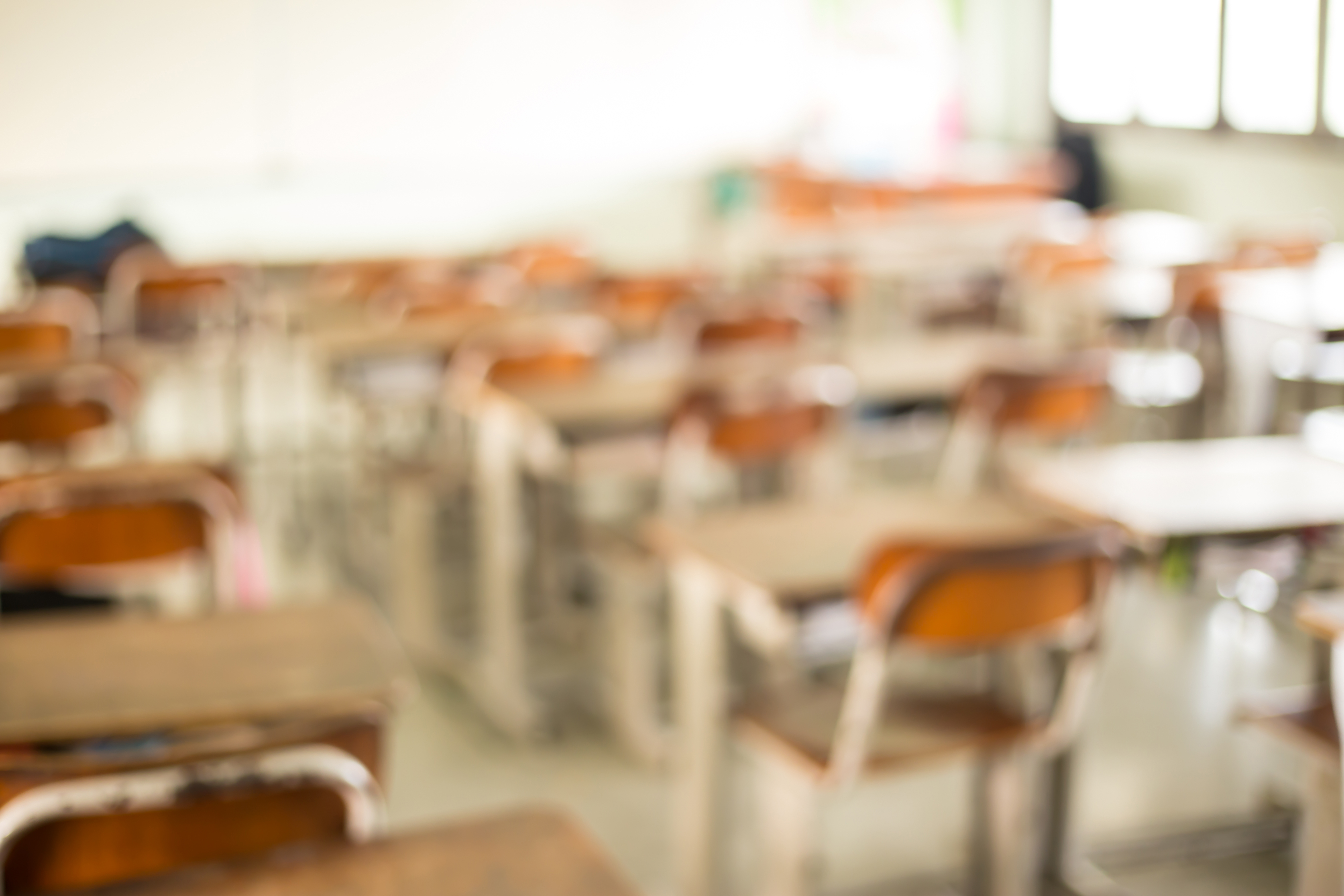 Defocused Image Of Blank Chairs And Tables At Classroom