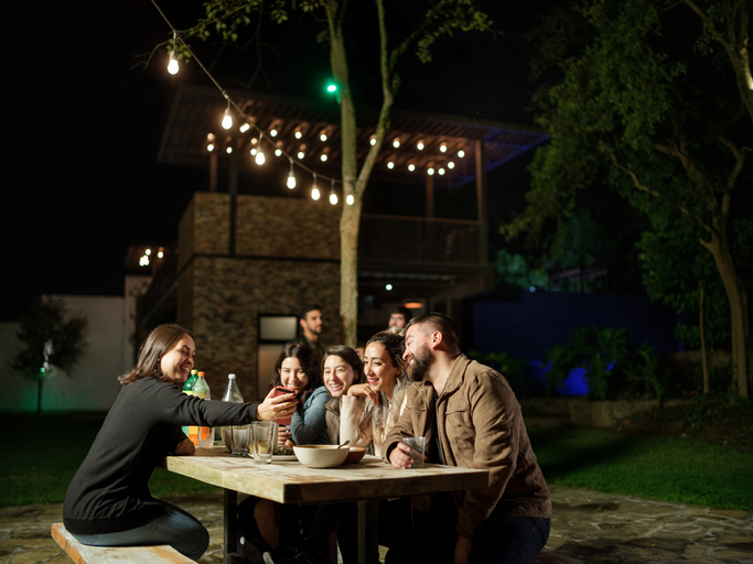 Friends having fun and looking at cellphone at night