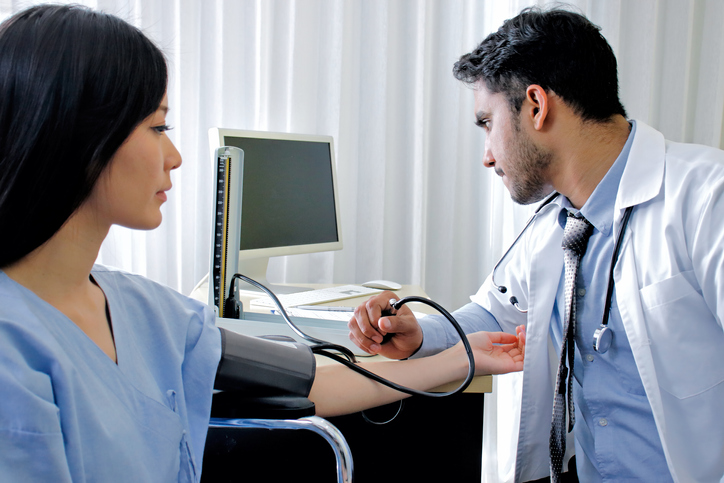 Healthcare, hospital and medicine concept. Doctor measuring blood pressure from patient