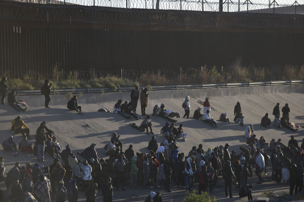 Migrants wait on the Mexican bank of the Rio Grande in Ciudad Juarez
