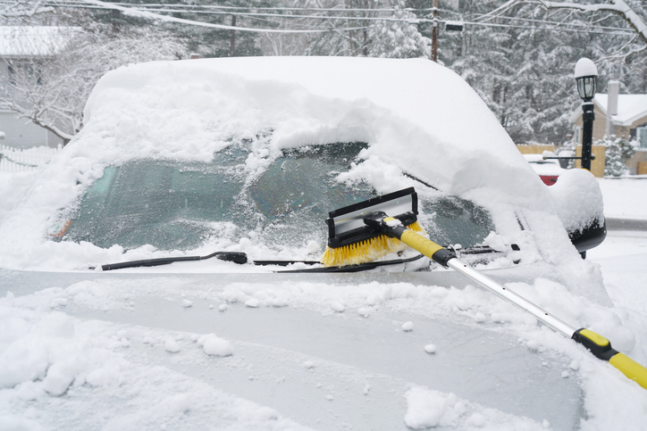 removing snow on the car window after snow storm