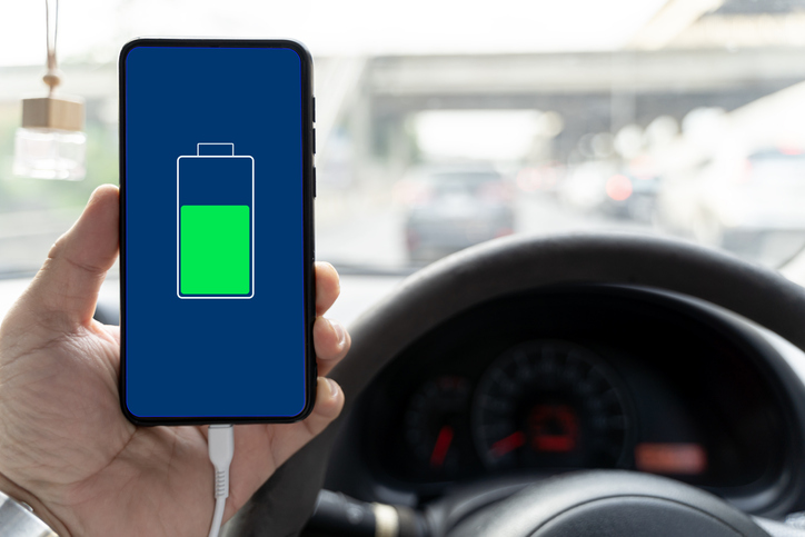 Mobile phone ,smartphone, cellphone is charged ,charge battery with usb charger in the inside of car. modern black car interior.