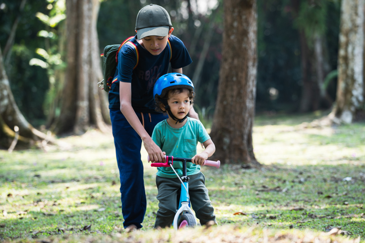 two sibling boys playing balanced bike