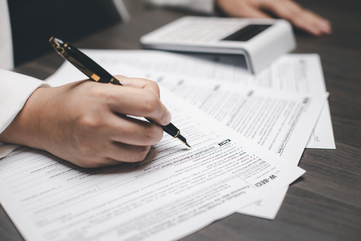 US IRS 1040 form or US Individual income tax Concept, accountant holding pen working on calculator business with data accounting documents and a laptop, pay tax in 2023 years,new year 2024 tax concept